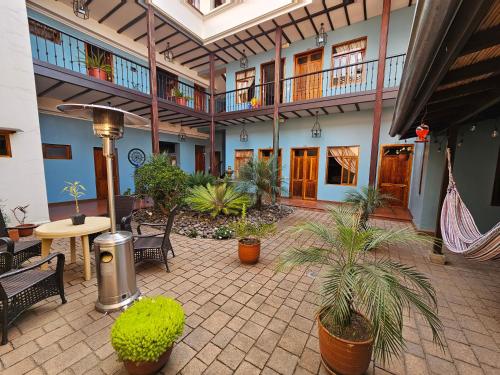 un patio con sillas y plantas en un edificio en Casa Hibiscus Boutique Hotel en Cuenca