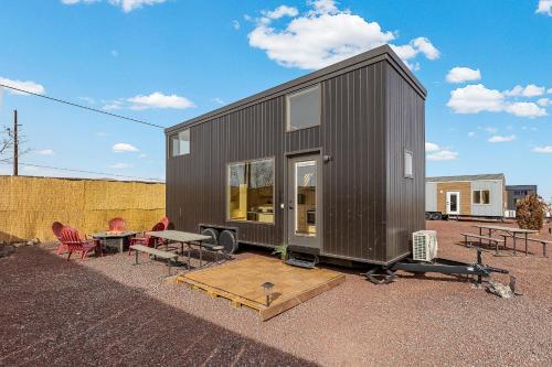 una pequeña casa negra con mesa y sillas en Tiny home near Grand Canyon sleeps 5, epic views!, en Flagstaff