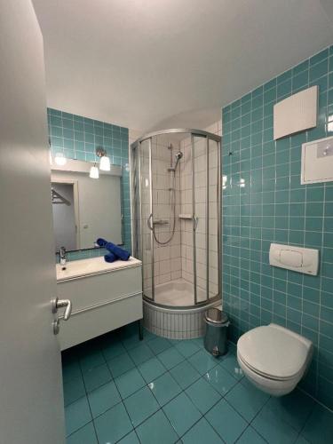 a bathroom with a shower and a toilet and a sink at Villa Parkblick App. 4 in Kühlungsborn