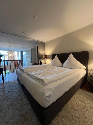 a bedroom with a large bed with white sheets and pillows at Villa Parkblick App. 4 in Kühlungsborn