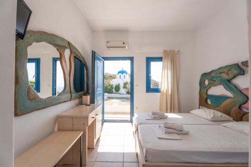 a bedroom with two beds and a mirror at Fanari Art in Ios Chora