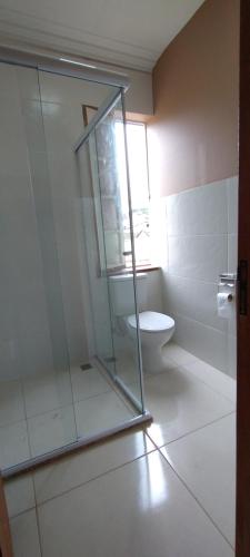 ein Bad mit einer Glasdusche und einem WC in der Unterkunft Pousada Vale do Café in Miguel Pereira