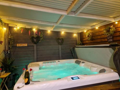bañera con agua azul en la habitación en The Log Cabin, en Waterford