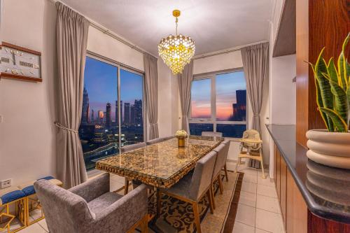 a dining room with a table and chairs and a large window at Spectacular Burj & Fountain View - Luxurious 3 Bedrooms & Maids room - The Residences in Dubai