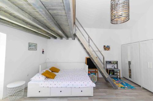 a white bedroom with a bed and a staircase at Villa Agora - Betina in Betina