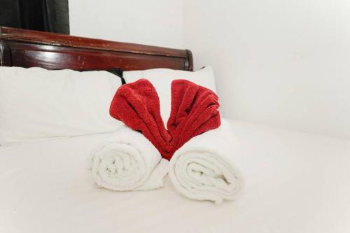 Una cama con dos toallas rojas. en Villa Vacacional, Playa Pascual, en Santa Bárbara de Samaná
