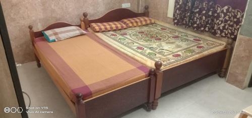 a bed with a wooden frame with a quilt on it at VIMAL RESIDENCY in Vellore
