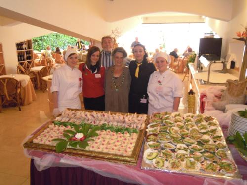 a group of people standing in front of a table of food at Beach Hotel Du Lac Malcesine in Malcesine