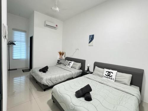 two beds in a bedroom with white walls at The Moment Homestay # WIFI TV Washer in Taiping