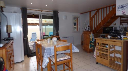une cuisine et une salle à manger avec une table et des chaises dans l'établissement Pavillon T3 Mezzanine, La Baie des Oliviers III, Narbonne Plage, à Narbonne-Plage