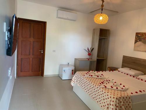 a bedroom with a bed and a brown door at Pousada Águas de Tamandaré in Tamandaré
