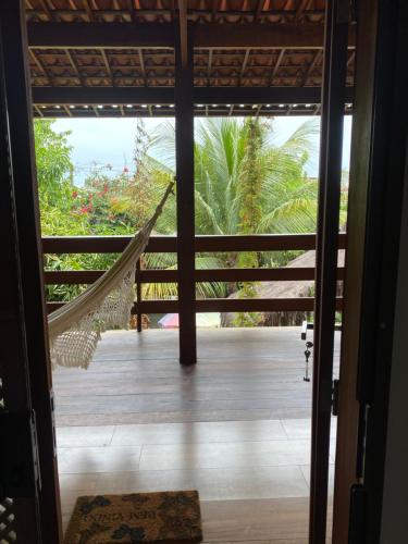 a hammock on the porch of a house at Pousada Águas de Tamandaré in Tamandaré