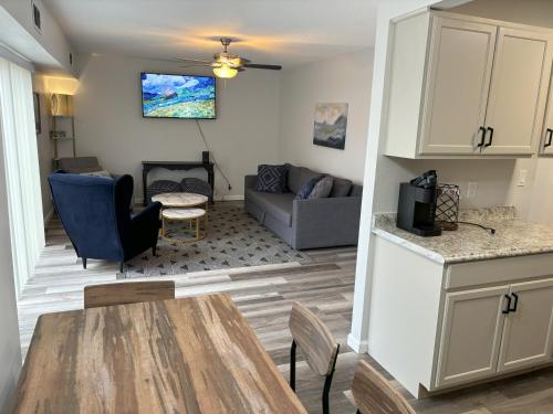 een keuken en een woonkamer met een tafel en een bank bij Peaceful Park 2 Bedroom Remodeled Family Suite in Granite City