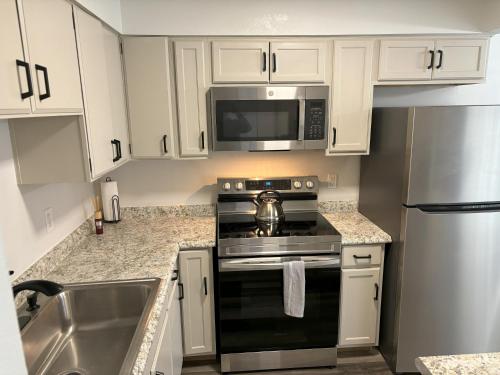 een keuken met een fornuis en een magnetron bij Peaceful Park 2 Bedroom Remodeled Family Suite in Granite City