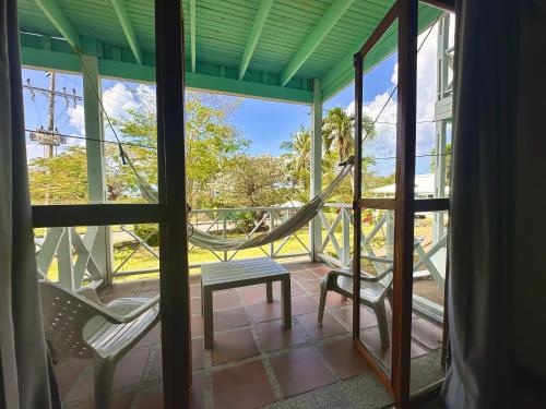 a screened in porch with a hammock and two chairs at South West Bay Cabañas in Providencia