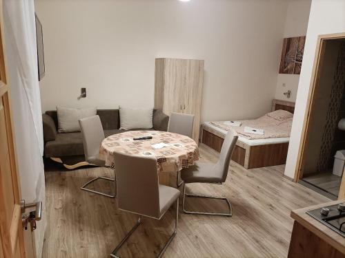 um quarto com uma mesa e cadeiras e um sofá em Elizabeth Apartman em Makó