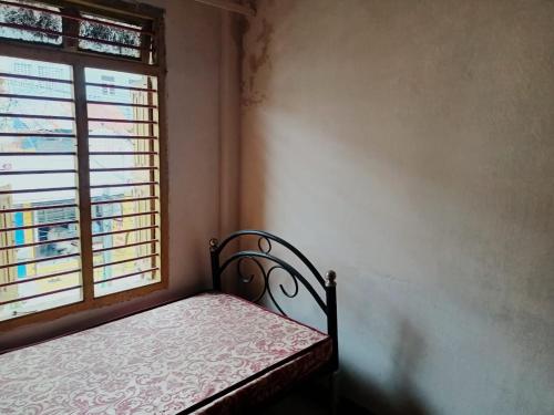 a small bedroom with a bed and a window at SS GUEST HOUSE & PG in Kumbakonam