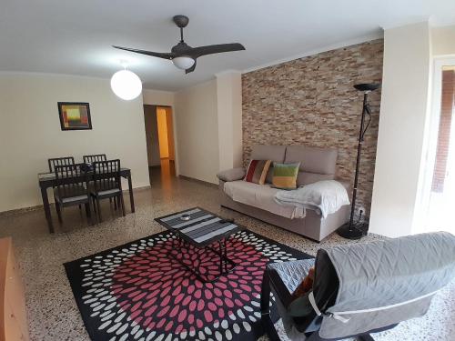 a living room with a couch and a brick wall at LAS 4 ESTACIONES in Elda