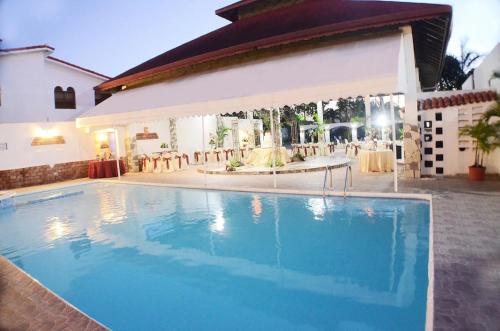 a large swimming pool in front of a house at Hotel Tropicana Santo Domingo in La Viva