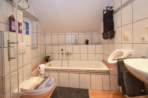 a bathroom with a tub and a toilet and a sink at Ferienhaus Auszeit in Westoverledingen