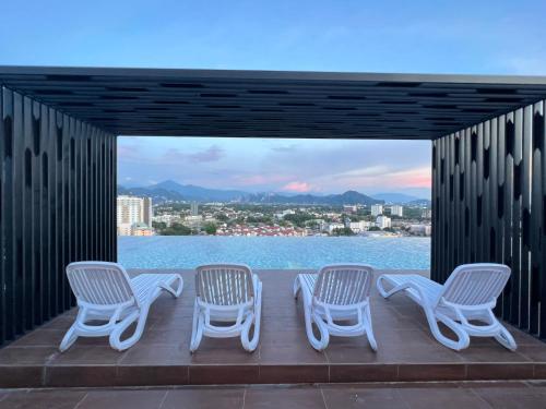 a group of chairs on a deck with a view of the water at BlissFul Homestay_Horizon@IPOH in Ipoh