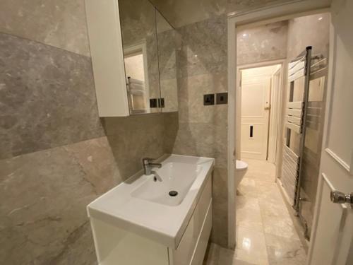 a bathroom with a white sink and a toilet at Chelsea in London