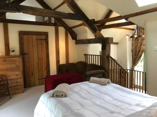 um quarto com uma cama branca e uma cadeira em Luxury Exmoor Barn conversion with Sauna em Exford