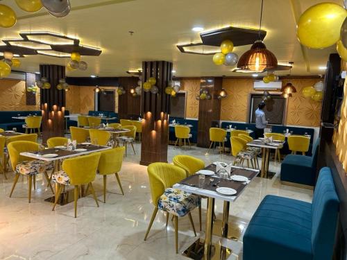 a dining room with tables and yellow chairs at HOTEL IMPERIAL in Aurangābād