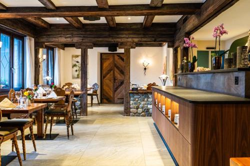 un restaurante con techos de madera, mesas y sillas en Hotel Allalin, en Saas-Fee