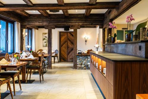 a restaurant with wooden ceilings and tables and chairs at Hotel Allalin in Saas-Fee