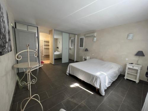 1 Schlafzimmer mit einem weißen Bett und einem Badezimmer in der Unterkunft maison 180 m² proche de Beaumes de Venise in La Roque-Alric