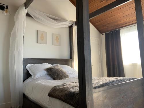 a bedroom with a canopy bed and a window at domaine des mésanges in Beaupré
