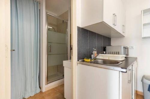 a small kitchen with a sink and a shower at Location 2 pièces sur EZE à 3km de MONACO (2) in Èze