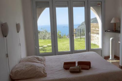 a bedroom with a large bed with two towels on it at Location 2 pièces sur EZE à 3km de MONACO (2) in Èze