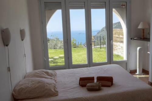a bedroom with a large bed with two towels on it at Location 2 pièces sur EZE à 3km de MONACO (2) in Éze