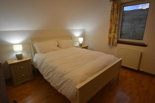een slaapkamer met een bed en twee nachtkastjes met lampen bij La Bergerie in Stein