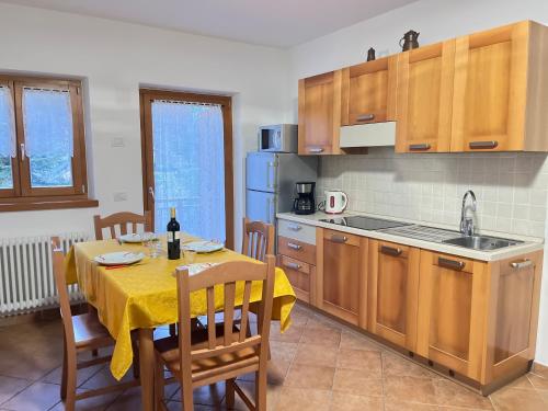 uma cozinha com uma mesa com uma toalha de mesa amarela em Maso Gaitem em Drena