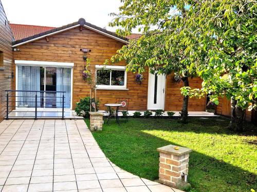 Cette maison dispose d'une terrasse avec une table dans la cour. dans l'établissement Studio Mer & Aa-terrasse-jardin-WIFI-parking-classé 3 étoiles, à Grand-Fort-Philippe