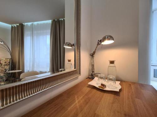 een kamer met een grote spiegel en een tafel met glazen bij Soleil Rooms - Pure Living in the City Center in Hannover