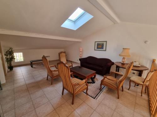 un salon avec un canapé, une table et des chaises dans l'établissement Villa Les Femades, à Laroque-des-Albères