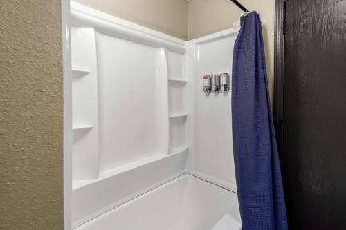 La salle de bains est pourvue d'une douche et d'un rideau de douche bleu. dans l'établissement Stonegate Lodge Bear's Den Kitchen, Pool, Firepit, WIFI ,Smart TVs, à Eureka Springs