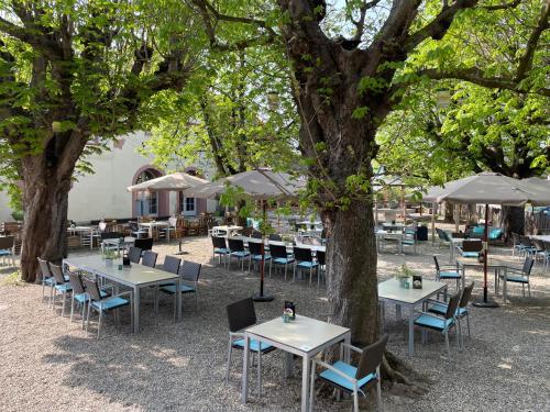 a group of tables and chairs under some trees at Rayers Boutique-Hotel 