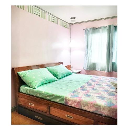 um quarto com um beliche e um edredão verde em Fely's transient house em Puerto Princesa
