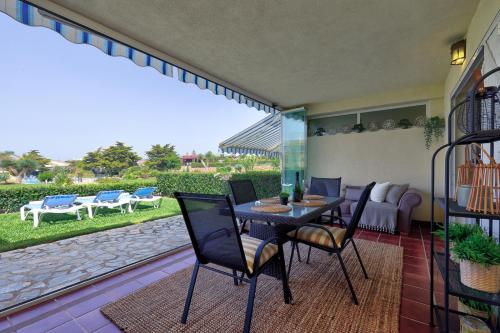 La Cala gorgeous 2 bedroom apartment with stunning gardens, pools and sea views في ميخاس كوستا: فناء مع طاولة وكراسي وأريكة