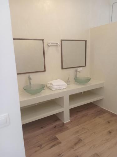 a bathroom with two sinks and two mirrors at Villa Tima in Sali Nianiaral