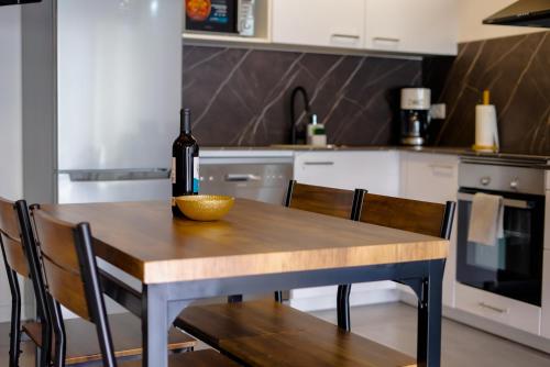a bottle of wine sitting on a wooden table in a kitchen at Casa Luna Rural Con Piscina y Jardín in Ourense