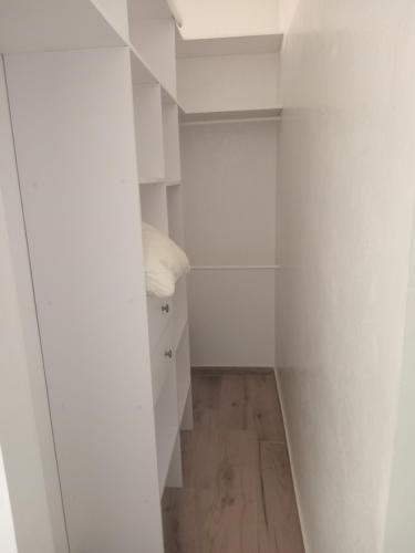 a room with white walls and a hallway with white cabinets at Villa Tima in Sali Nianiaral