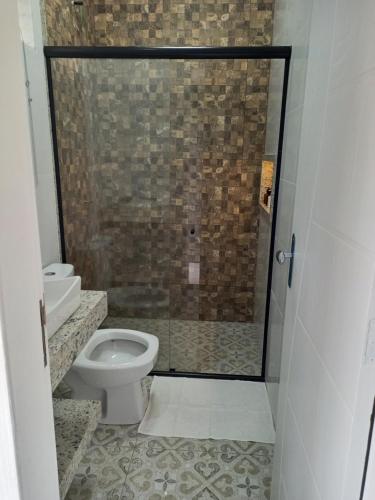 a bathroom with a toilet and a glass shower at Pousada & Hotel Fazenda Segredo Das Águas in Alto Caparao