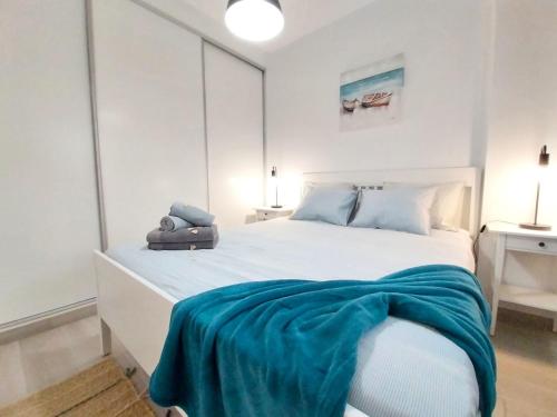 een slaapkamer met een bed met een blauwe deken erop bij Blue Velvet by Sea You There Fuerteventura in Corralejo