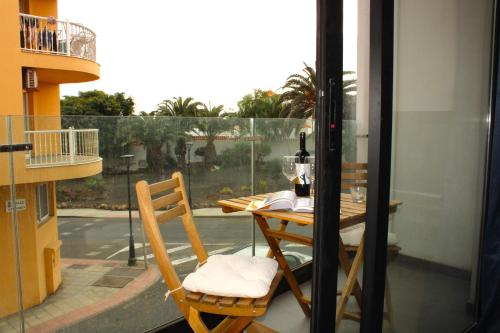 een tafel en stoelen op een balkon met een raam bij Blue Velvet by Sea You There Fuerteventura in Corralejo